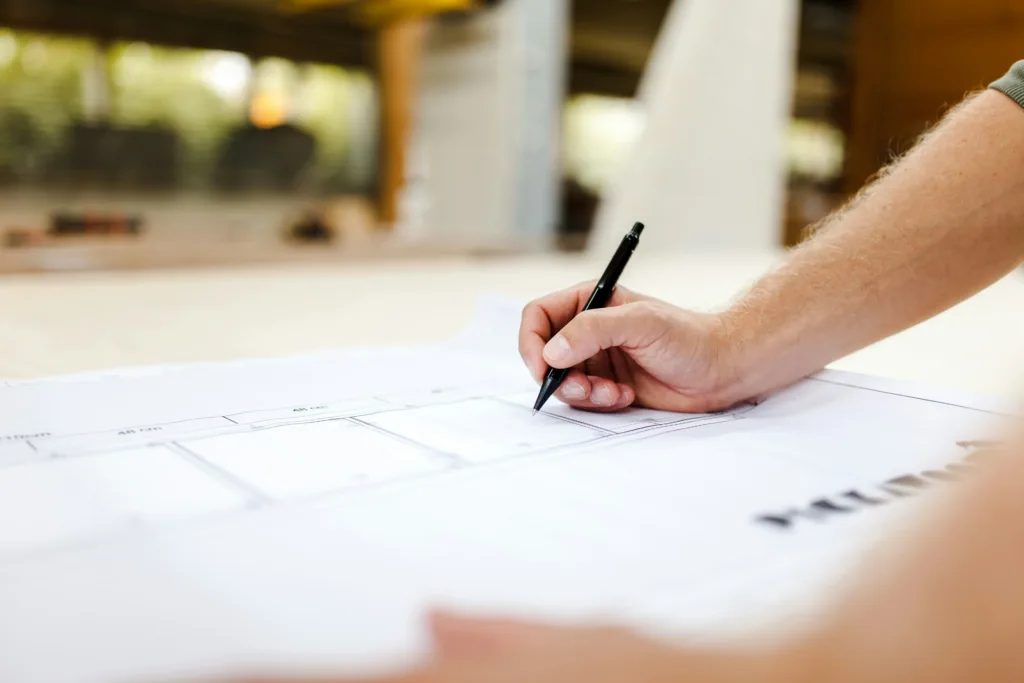 A hand with a pencil on paper working as an engineer.