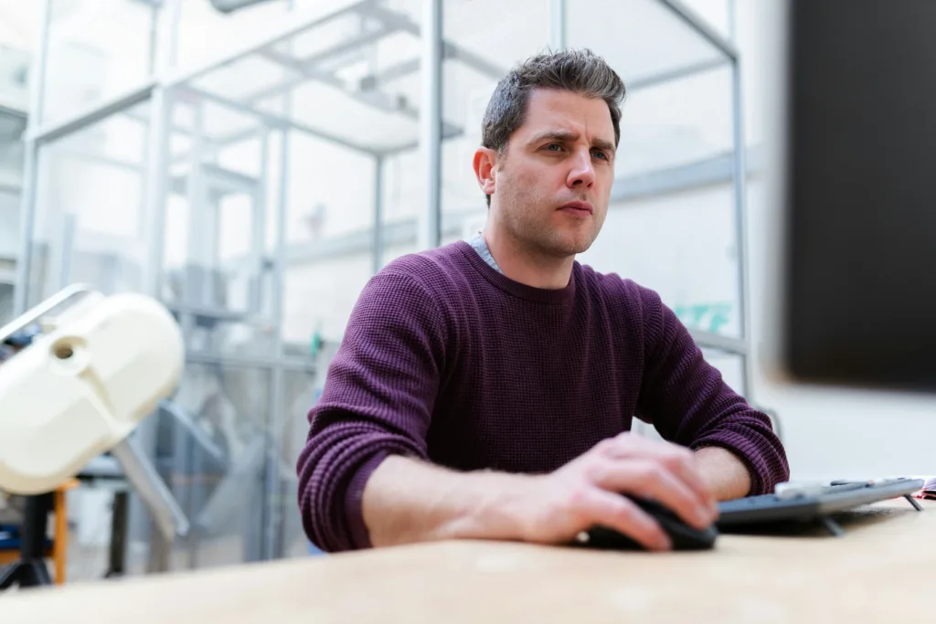 A man working on a computer in a lab demostrating What Is the Difference Between a Database Engineer vs Data Engineer.