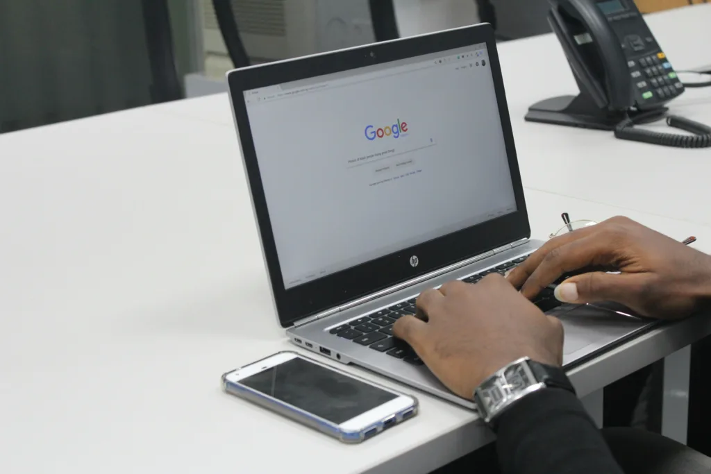 A man entering a search query into google on his laptop.