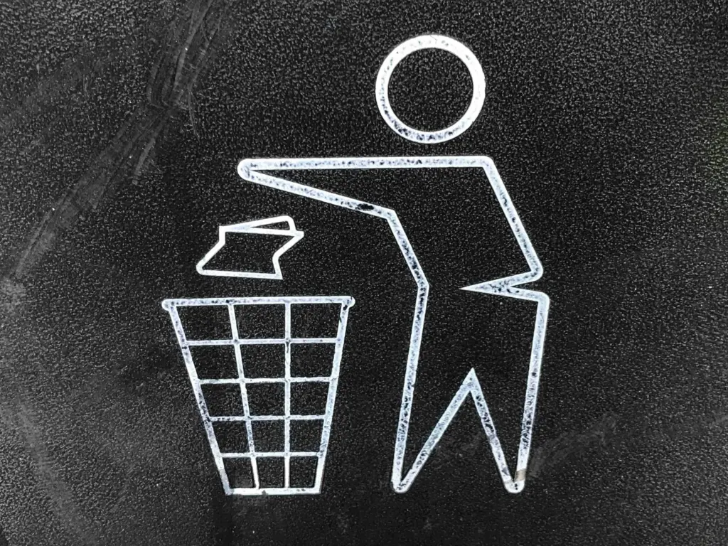 White stick figure throwing out garbage on  grey background.