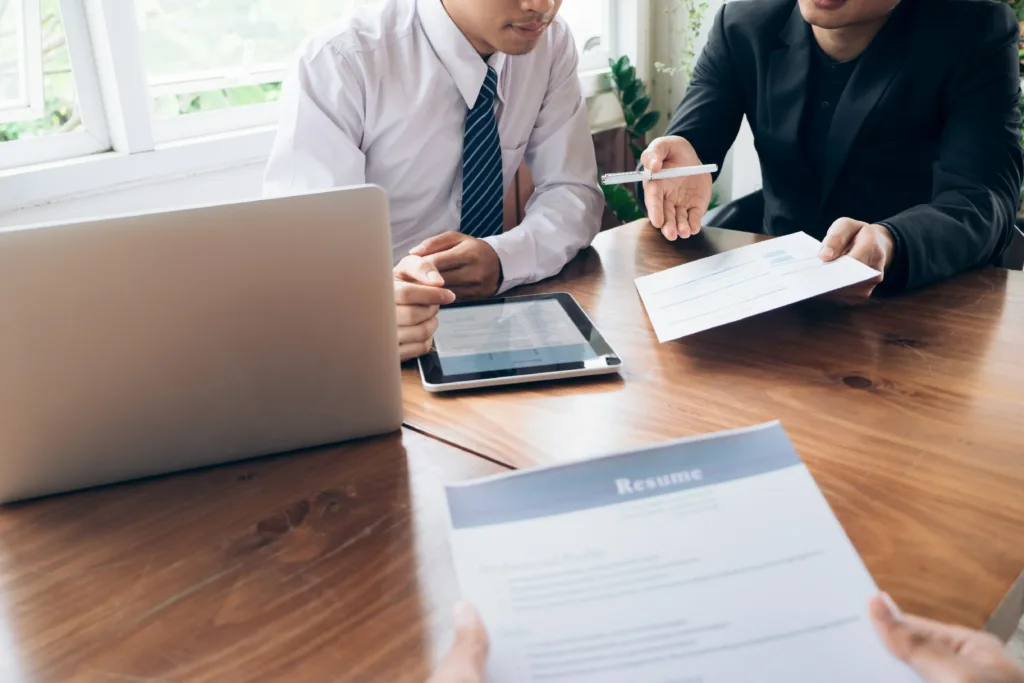 Two people in business attire across a table evaluating a cloud engineer resume.